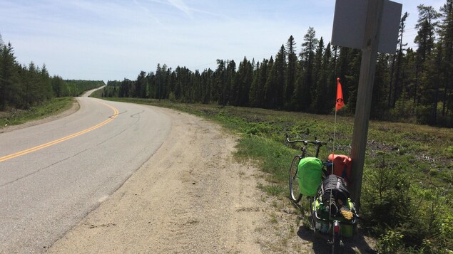 Le vélo accoté sur un poteau, face à la route. Le vélo accoté sur un poteau, face à la route.