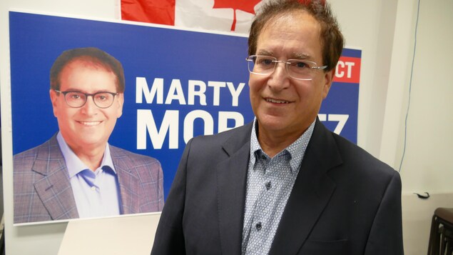 Marty Morantz devant son affiche électorale. 