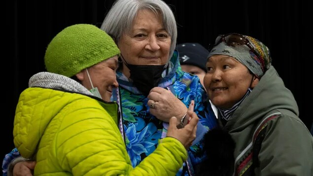 A woman glances up at Gov. Gen. Mary Simon after taking a photo together following a community gathering Tuesday in Kangiqsualujjuaq, Que. Simon is using her week-long visit to Nunavik to draw attention to poor internet access, and the marginalization of Indigenous languages. (Adrian Wyld/The Canadian Press)