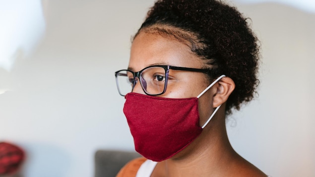Une femme portant un masque en tissu.