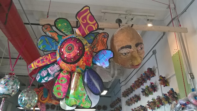 Un énorme masque et une grande « fleur officielle d'Athens » accrochés au plafond de l'atelier Passion Works Un énorme masque et une grande « fleur officielle d'Athens » accrochés au plafond de l'atelier Passion Works