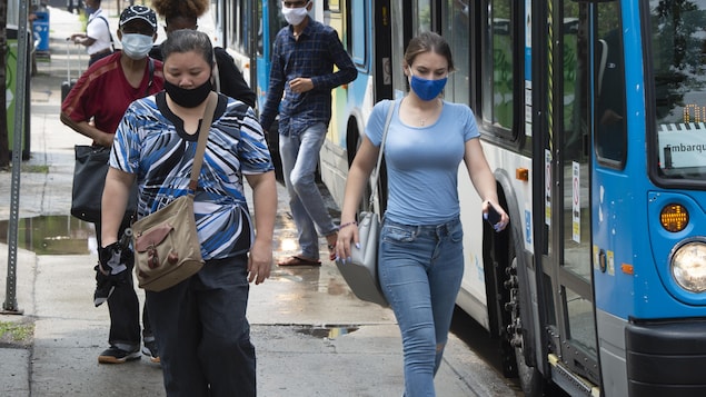 Des passagers débarquant d'un autobus à Montréal.