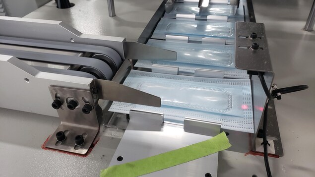 Des masques d'intervention avec fenêtre transparente sur une chaîne de montage.