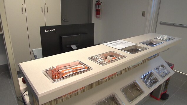 L'accueil de la salle d'injection du centre Spectre de rue, où du matériel est disponible pour les usagers, dans des bacs placés devant un poste de travail informatique. L'accueil de la salle d'injection du centre Spectre de rue, où du matériel est disponible pour les usagers, dans des bacs placés devant un poste de travail informatique.