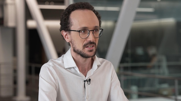 Un homme parle à la caméra.