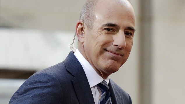 Il regarde, souriant, le public Il regarde, souriant, le public