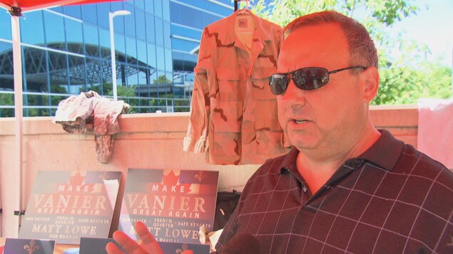 Le candidat au poste de conseiller municipal du quartier Rideau-Vanier, Matt Lowe, sous un kiosque avec des pancartes sur lesquelles on peut lire « Make Vanier great again » Le candidat au poste de conseiller municipal du quartier Rideau-Vanier, Matt Lowe, sous un kiosque avec des pancartes sur lesquelles on peut lire « Make Vanier great again »