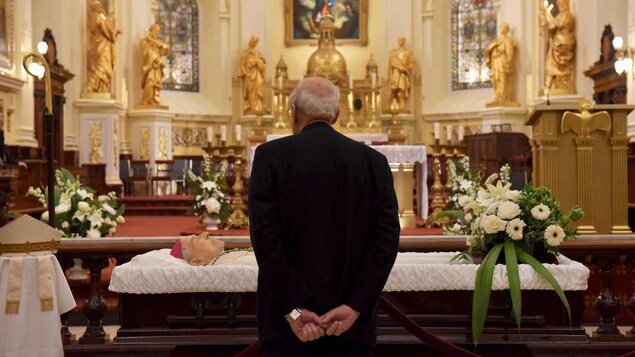 Un prêtre se recueille devant le cercueil de Mgr Maurice Couture