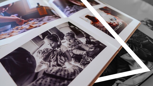 Des albums photo de famille sont ouverts sur la table.