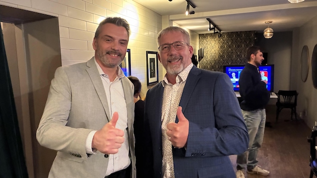 Deux hommes souriants font un pouce en l'air