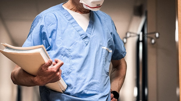 Un médecin à l'urgence du centre hospitalier de Port-Cartier tient des documents entre ses bras.