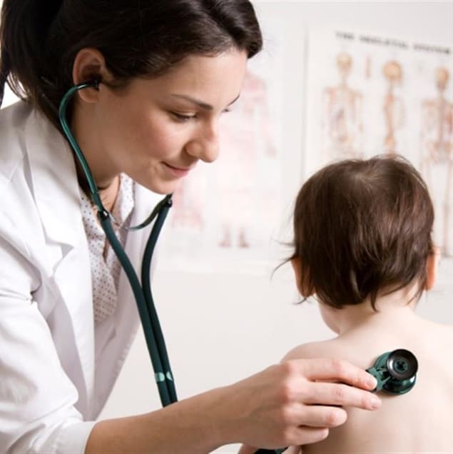 Un médecin de famille ausculte un enfant.