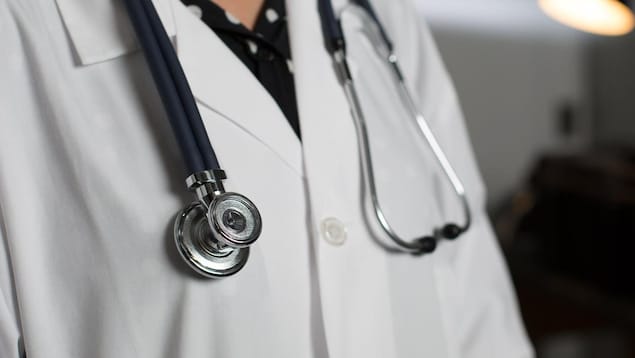 Haut de corps d'un médecin portant un stéthoscope autour du cou.