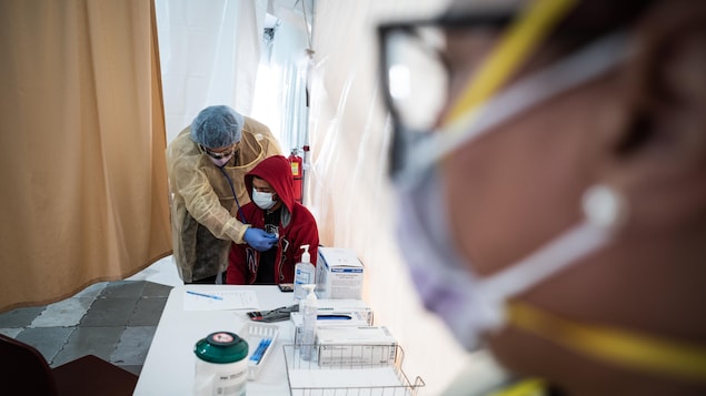 Le médecin se sert d'un stéthoscope auprès d'un patient.