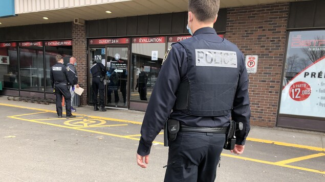 Des agents du SPVQ dans le stationnement du Méga Fitness Gym.