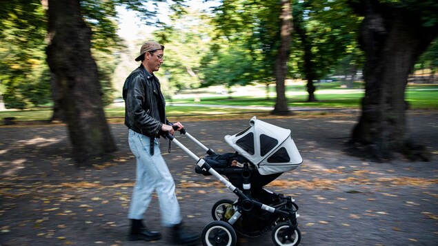 Isang lalaki itinutulak ang baby stroller.