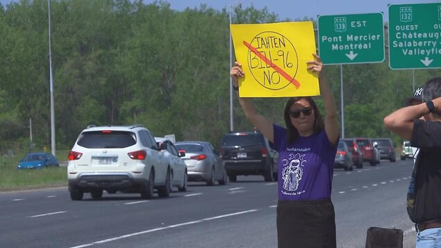 A woman holding a sign above her head during a protest.