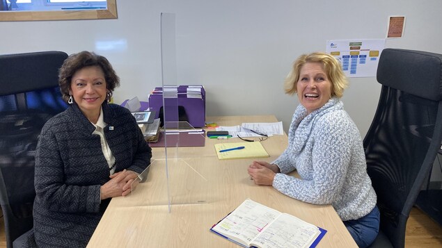 Deux femmes assies à une table.