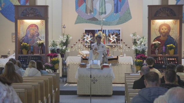 Le prêtre dit l'homélie en ukrainien en présence de plusieurs dizaines de fidèles. Ils suivent la messe de Pâques à la Holy Family Ukrainian Catholic Church à Winnipeg