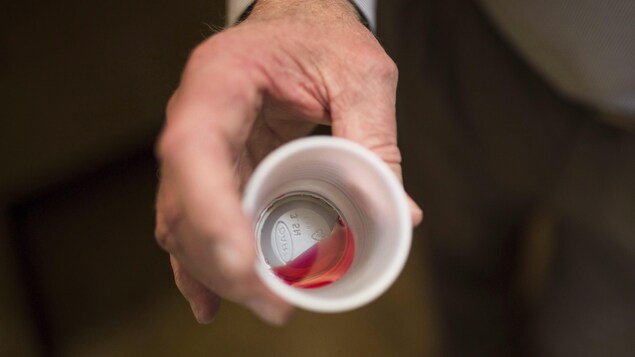 Un liquide rouge qui représente 35 mg de méthadone dans un gobelet de plastique.