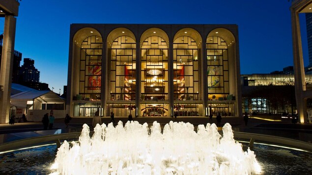 L'édifice du Metropolitan Opera de New York, la nuit, avec une fontaine juste devant. L'édifice du Metropolitan Opera de New York, la nuit, avec une fontaine juste devant.