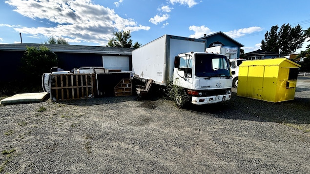 Des meubles entassés à l'extérieur à côté d'un camion