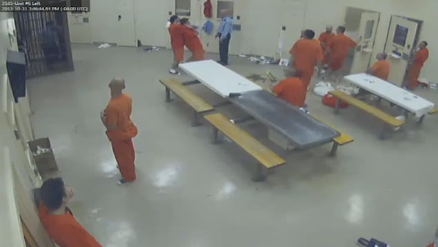 Image de caméra de surveillance dans une prison. Des détenus assistent à une agression Image de caméra de surveillance dans une prison. Des détenus assistent à une agression