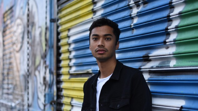 Le DJ Michael Brun regarde l'objectif en se tenant devant une grille de garage fermée et recouverte de graffitis. Le DJ Michael Brun regarde l'objectif en se tenant devant une grille de garage fermée et recouverte de graffitis.