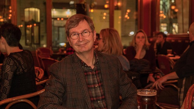 On voit Michel Dorais, de face, prenant place au bar L'Barouf On voit Michel Dorais, de face, prenant place au bar L'Barouf