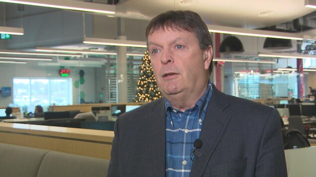 Un homme debout devant la caméra dans les studios de Radio-Canada. Un homme debout devant la caméra dans les studios de Radio-Canada.