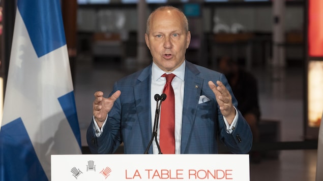 Michel Leblanc, debout derrière un lutrin, durant une conférence de presse.