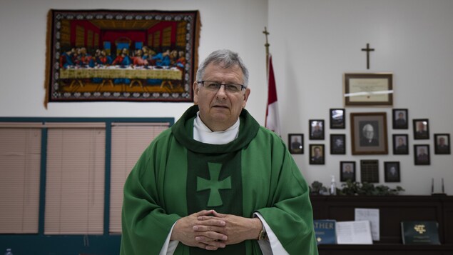 Le prêtre Michel Nault avec sa toge verte. 