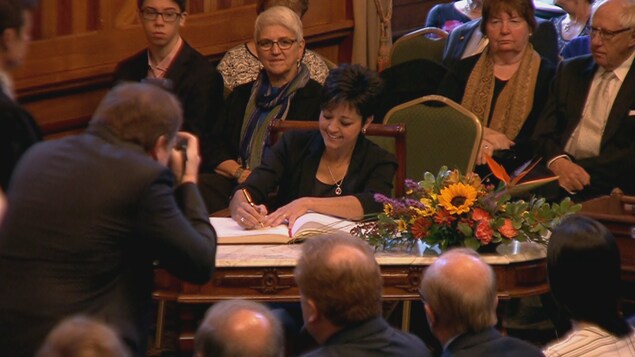 Michelle Conroy signe un document lors de la cérémonie d'assermentation. Michelle Conroy signe un document lors de la cérémonie d'assermentation.