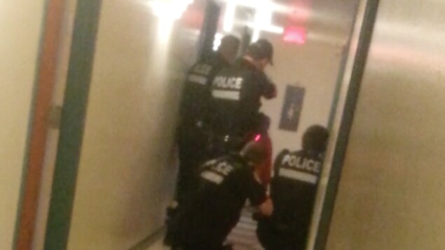 Des policiers du SPVM dans un couloir lors d'une opération visant à maîtriser Pierre Coriolan.