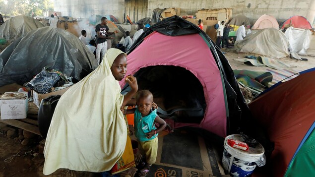 Une femme et son enfant devant une tente. Une femme et son enfant devant une tente.