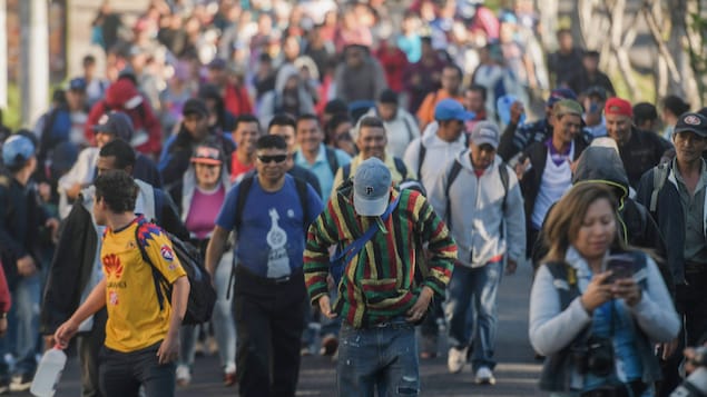 Des gens marchent en groupe dans une rue. Des gens marchent en groupe dans une rue.