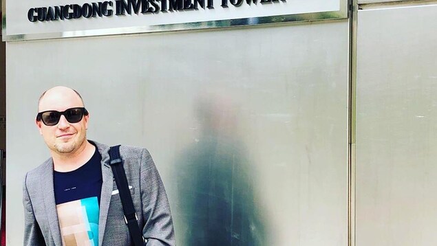 Mikael Charette devant une tour à bureaux en Chine.