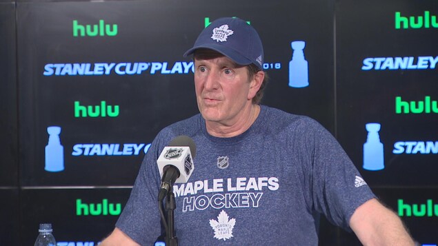 Photo de Mike Babcock portant un t-shirt et une casquette bleus des Leafs. Photo de Mike Babcock portant un t-shirt et une casquette bleus des Leafs.