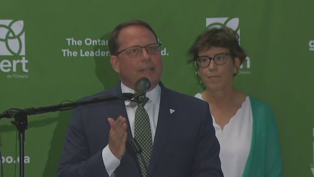 He makes his speech, his wife by his side.