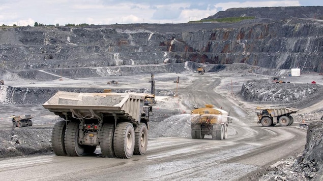 Au fond de la mine, des camions arrosent le sol. Au fond de la mine, des camions arrosent le sol.