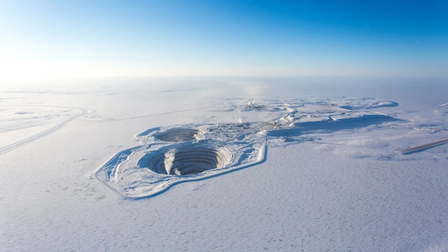 Un énorme trou dans la neige vu d'en haut est en fait la mine à ciel ouvert Diavik.