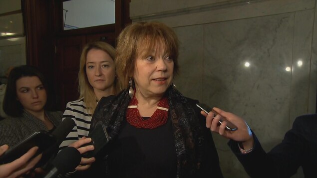 La ministre Hélène David, interrogée par les journalistes dans un corridor de l'Assemblée nationale du Québec.