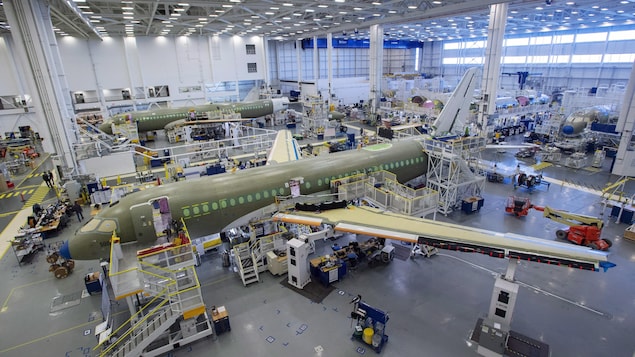 Une avion est en train d'être assemblé dans une usine.