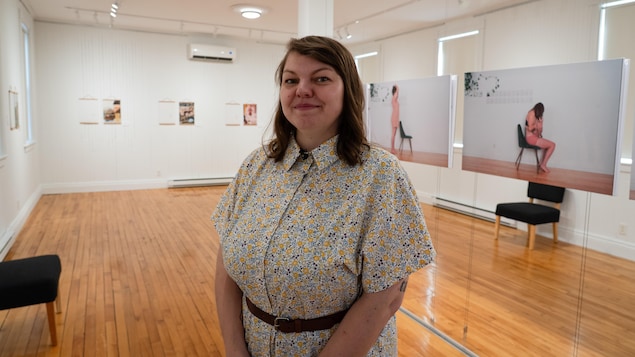 Une femme au milieu d'une salle d'exposition.