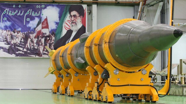Un missile repose sur un support dans un hangar.