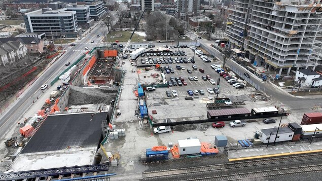Vue aérienne d'un stationnement près d'un chantier d'une station de train de banlieue.