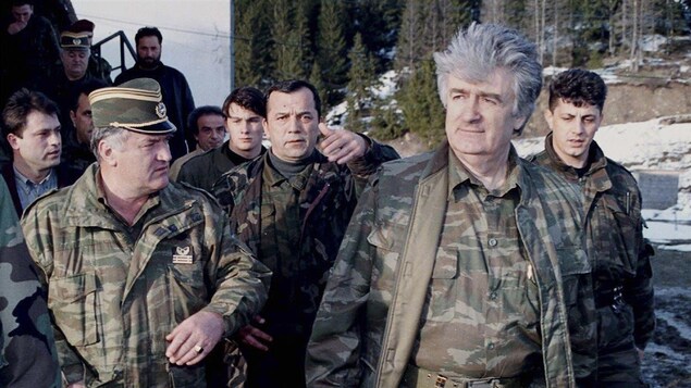 Des homme en tenue militaire marchent à l'extérieur. Des homme en tenue militaire marchent à l'extérieur.