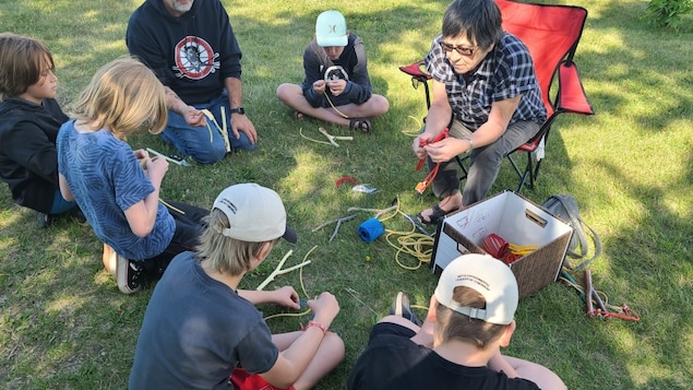 The Manitoba Métis Federation's Goodon, left, and Leah LaPlante help youth make slingshots. (Submitted by Will Goodon)