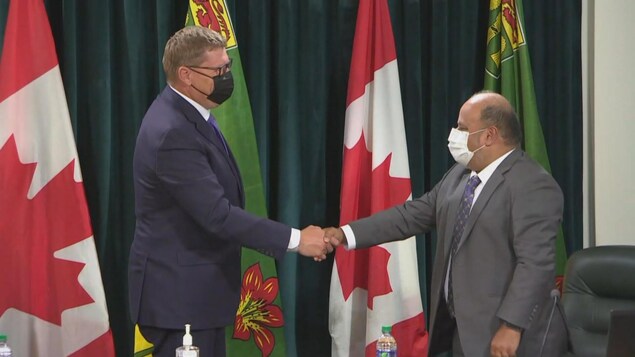 Scott Moe serre la main du docteur Saqib Shahab.