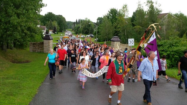 Un groupe de Mohawks de Kanesatake marchent en protestation contre le projet immobilier du Domaine des Collines d'Oka, le 12 août 2017. Un groupe de Mohawks de Kanesatake marchent en protestation contre le projet immobilier du Domaine des Collines d'Oka, le 12 août 2017.